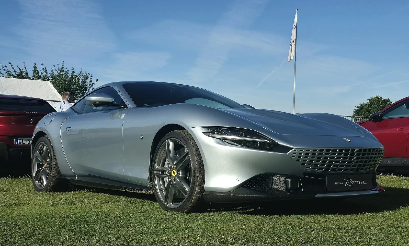 Silver Ferrari Roma coupe on grass, front three-quarter view