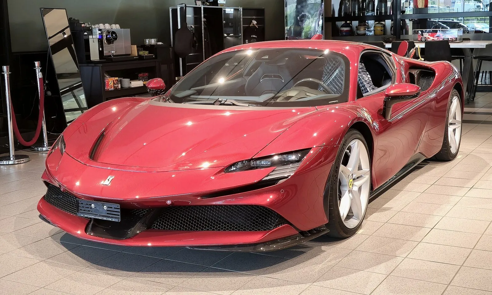 Red Ferrari SF90 Stradale in a showroom, front three-quarter view